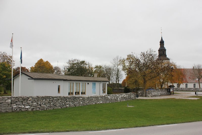 En vit envåningsbyggnad och en kyrka finns i närheten av vägen.