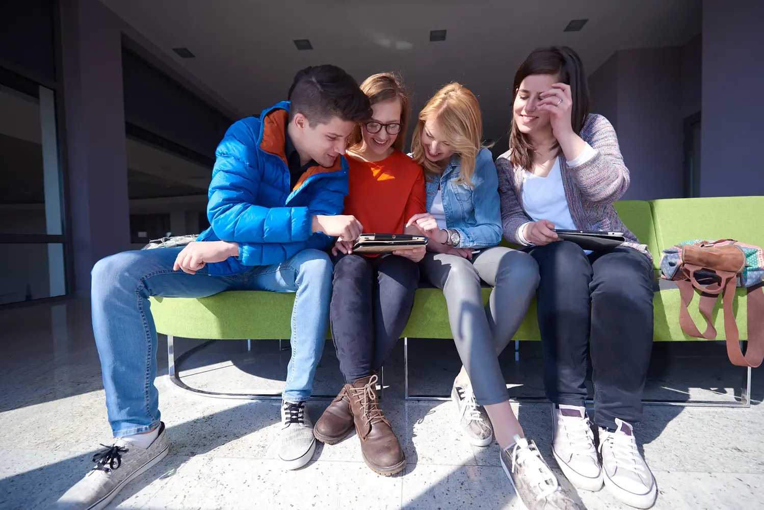 Ungdomar på en bänk, tittar på en mobiltelefon